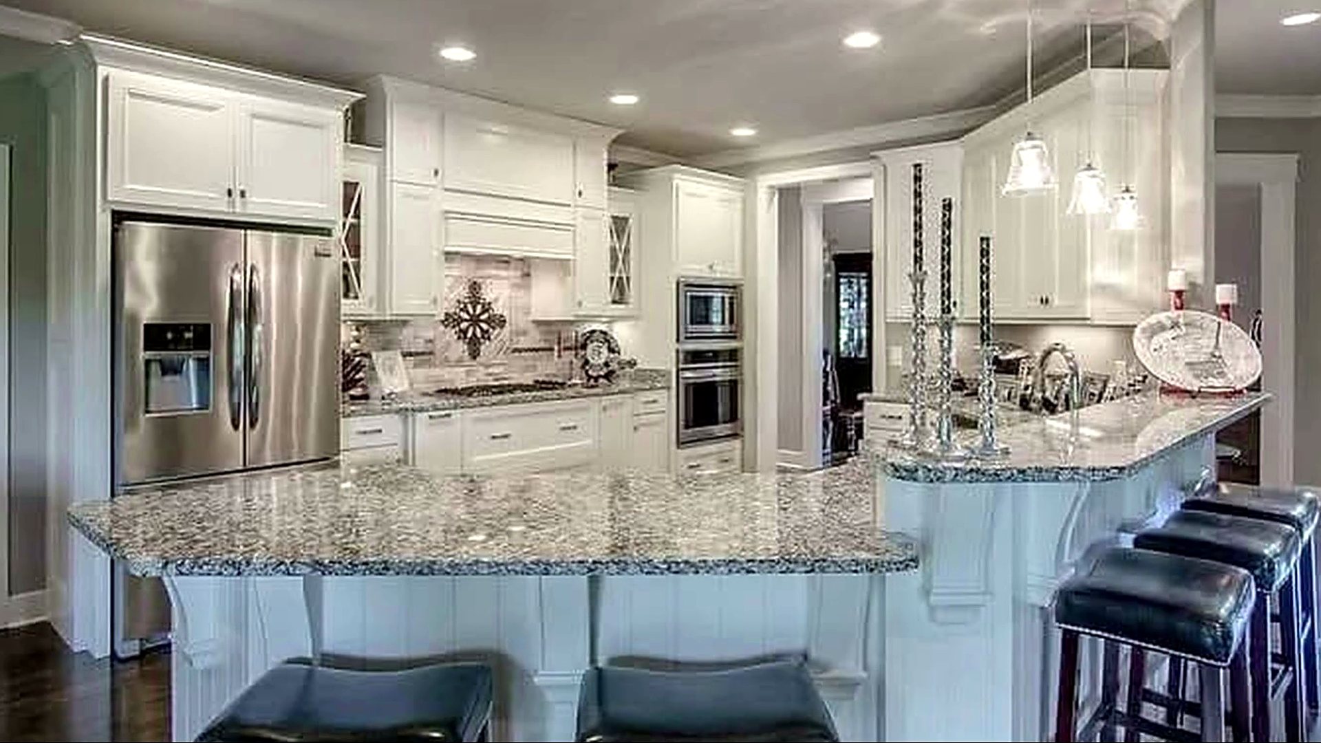 White kitchen with granite island in a home we built